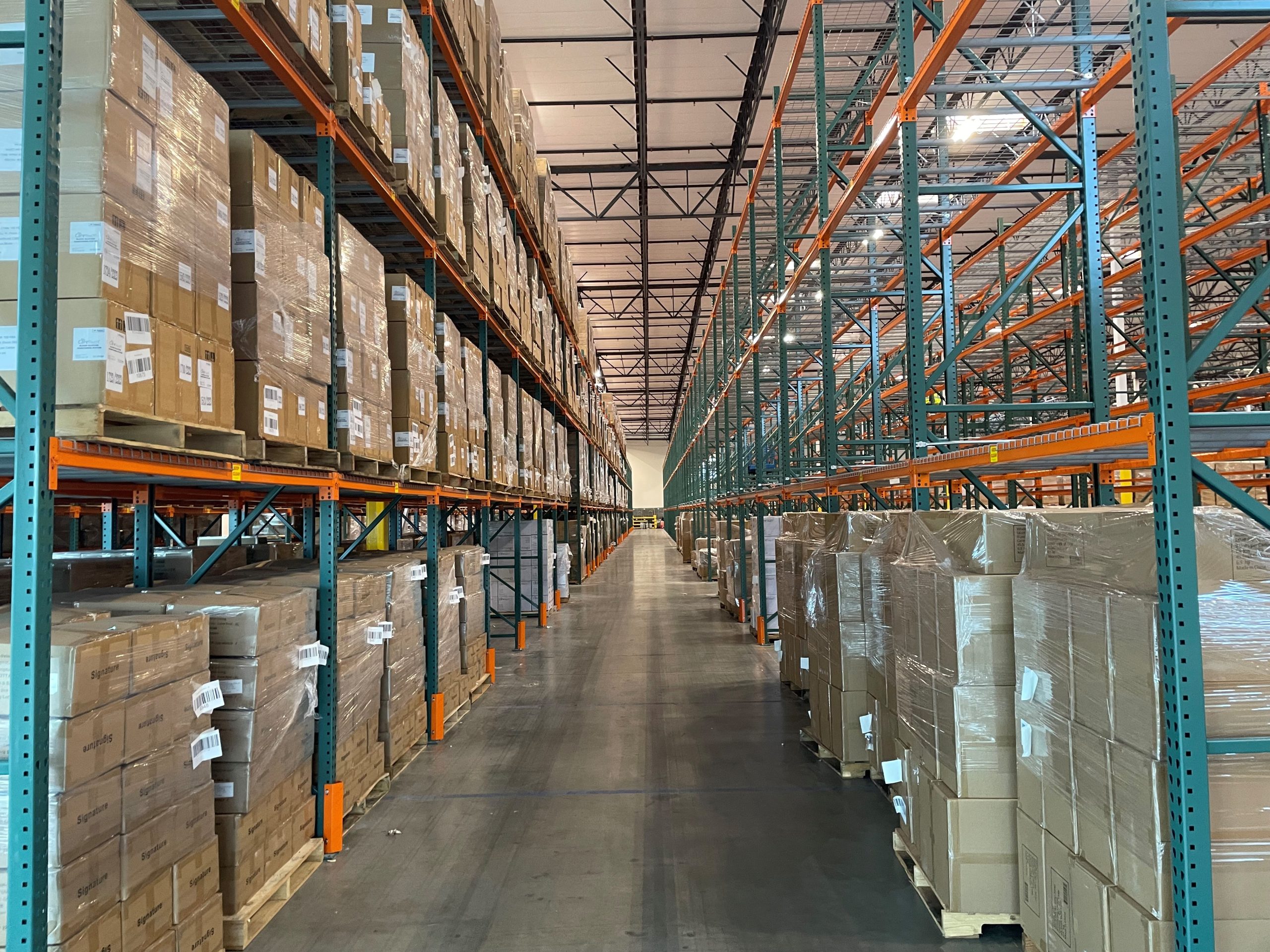Fully stocked warehouse aisles with pallets on racks
